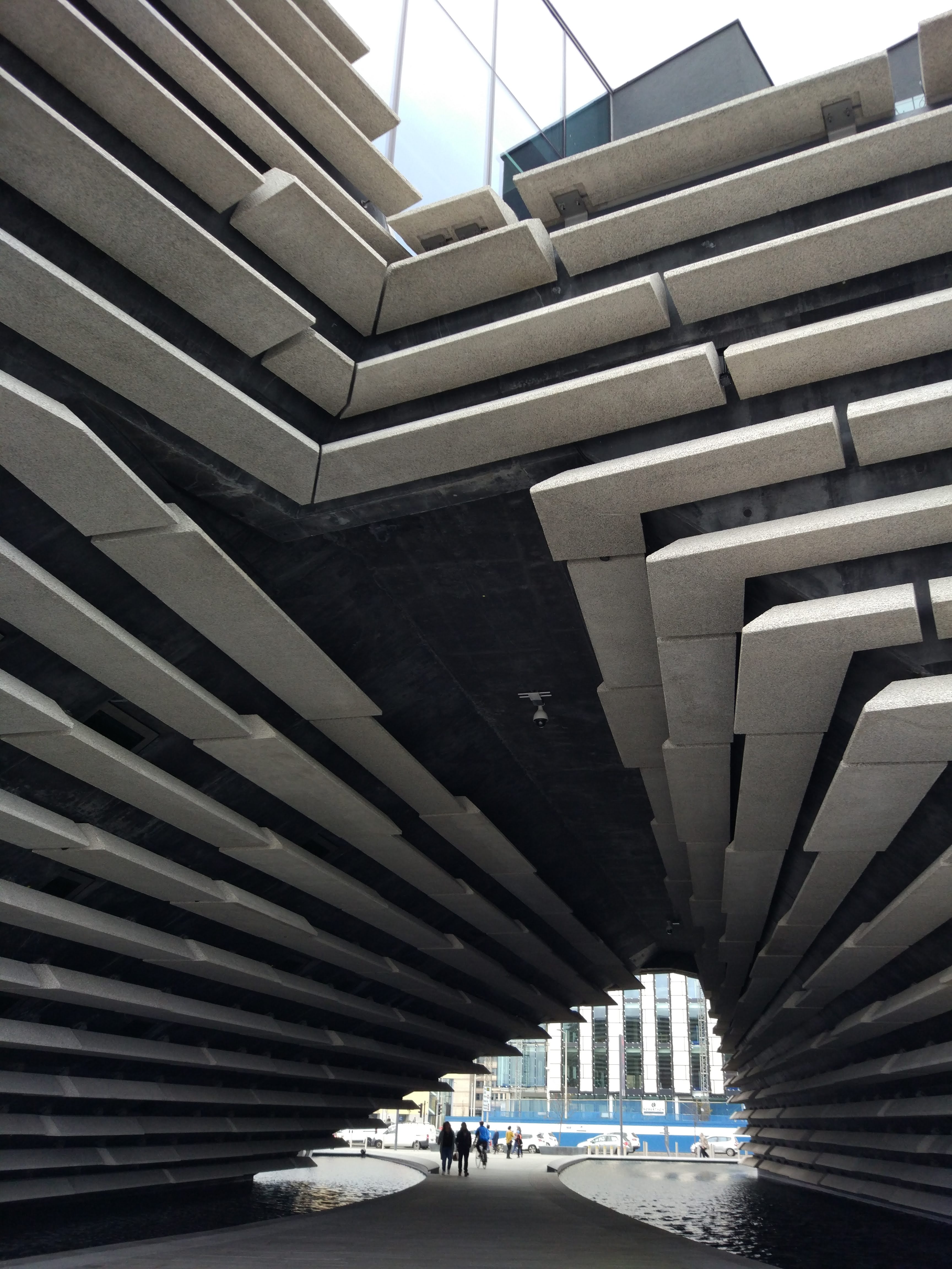 V&A Dundee photo taken looking through the buildings which looks like two up side down stairs meeting above ground building an arch